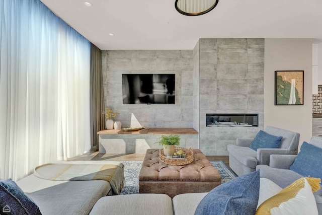 living area featuring a tiled fireplace, tile walls, and recessed lighting