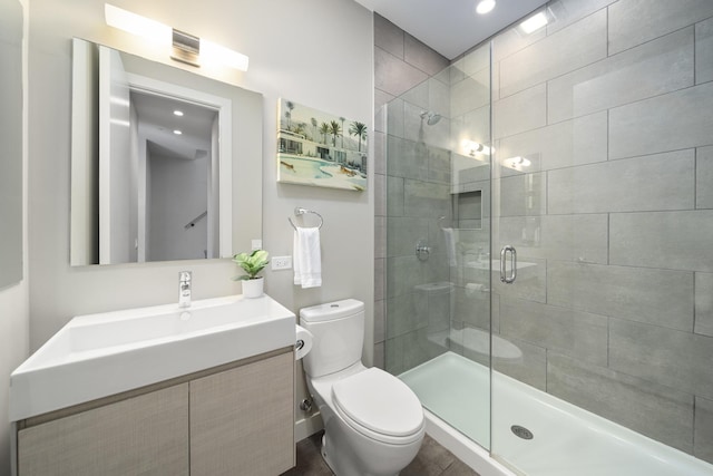 full bath featuring toilet, a stall shower, and vanity