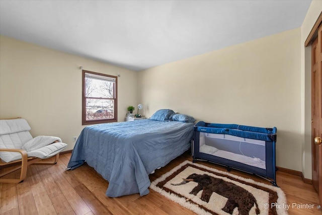 bedroom featuring hardwood / wood-style floors and baseboards