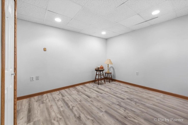 spare room featuring baseboards, wood finished floors, recessed lighting, and a paneled ceiling