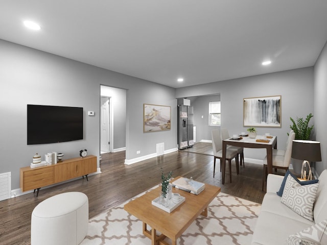 living room with baseboards, visible vents, wood finished floors, and recessed lighting