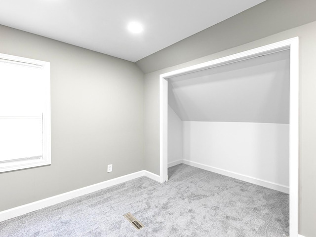 bonus room featuring baseboards, lofted ceiling, carpet flooring, and visible vents
