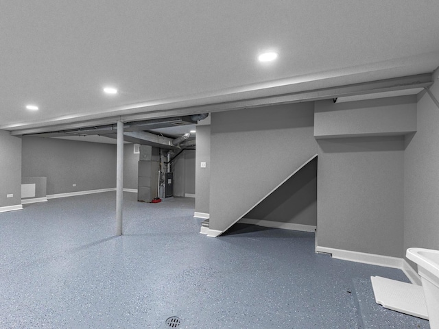 finished basement with baseboards and heating unit