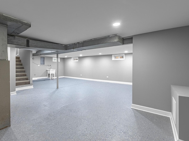 finished basement with baseboards, recessed lighting, stairs, and a sink
