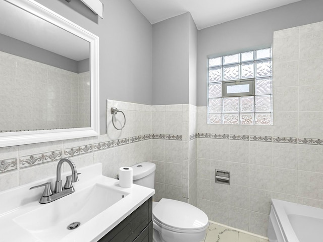 bathroom featuring a tub, toilet, vanity, and tile walls
