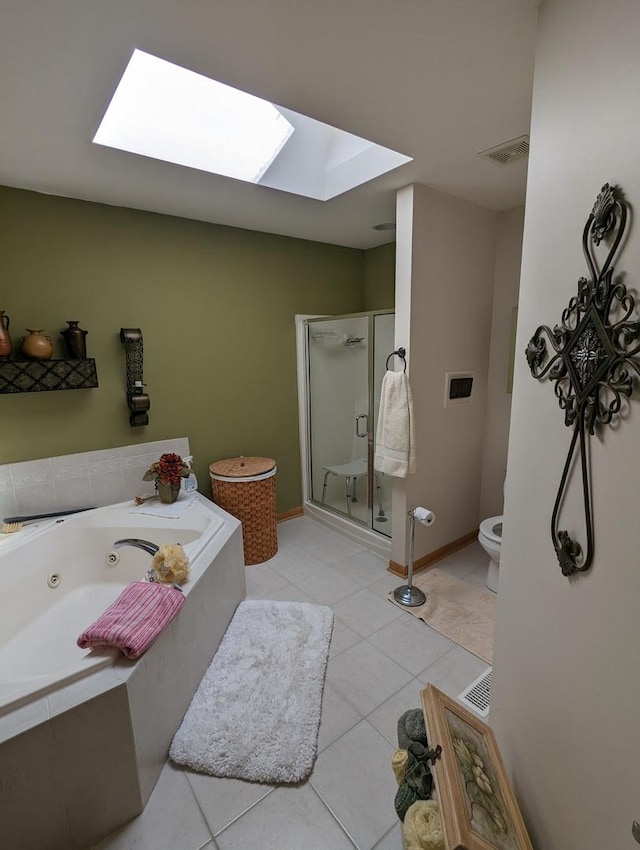 full bath featuring a stall shower, a skylight, a jetted tub, and tile patterned flooring