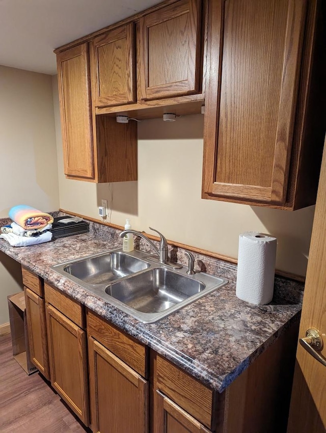 kitchen with a sink, dark countertops, and brown cabinets