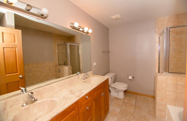 4312 S Saint Lawrence Ave Unit 1, Chicago, IL 60653 - full bath with tile patterned floors, a sink, a tile shower, and toilet