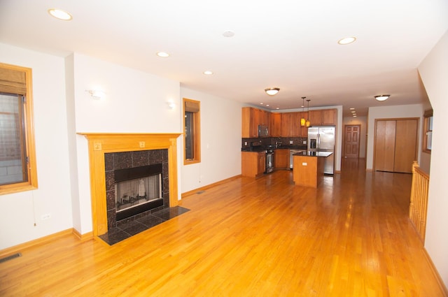 4312 S Saint Lawrence Ave Unit 1, Chicago, IL 60653 - unfurnished living room featuring recessed lighting, a tile fireplace, baseboards, and light wood-type flooring