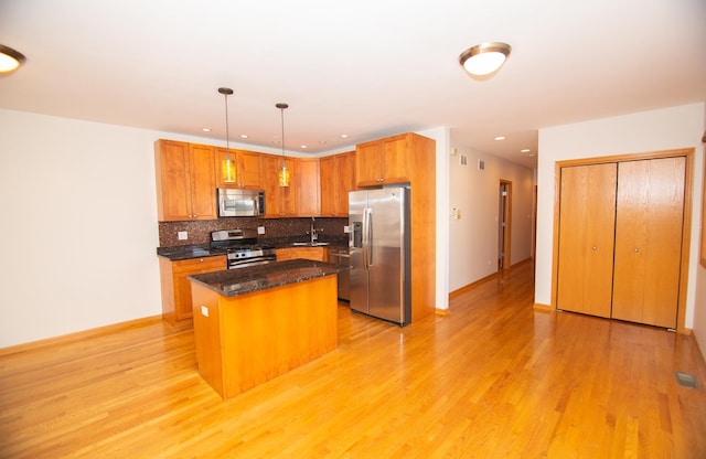 4312 S Saint Lawrence Ave Unit 1, Chicago, IL 60653 - kitchen featuring decorative backsplash, stainless steel appliances, light wood-style floors, and a center island