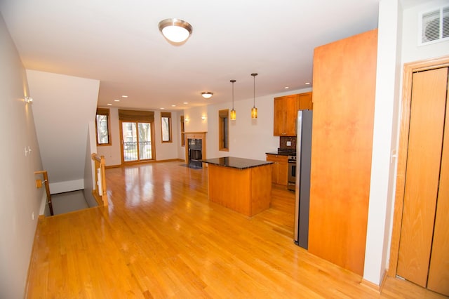 4312 S Saint Lawrence Ave Unit 1, Chicago, IL 60653 - kitchen with open floor plan, dark countertops, light wood finished floors, visible vents, and brown cabinetry
