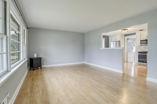 unfurnished room with light wood-style floors and baseboards