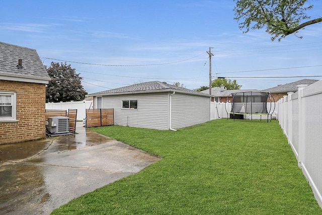 view of yard with a trampoline, a patio, and central AC unit