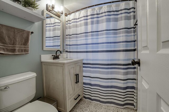 bathroom with toilet, vanity, and a shower with shower curtain
