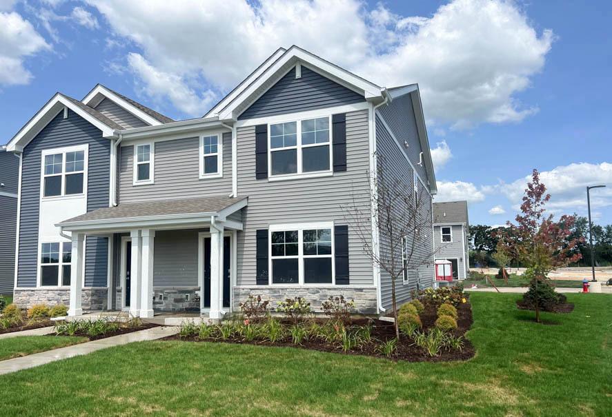 view of front of property with stone siding, covered porch, and a front lawn