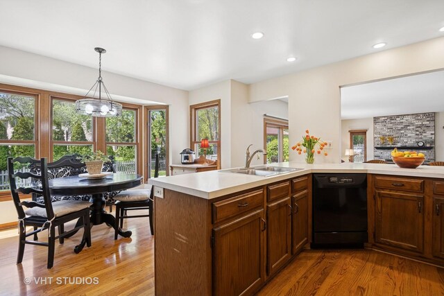 4230 Forest Glen Dr, Hoffman Estates, IL 60192 - kitchen with black dishwasher, a sink, light countertops, light wood finished floors, and healthy amount of natural light