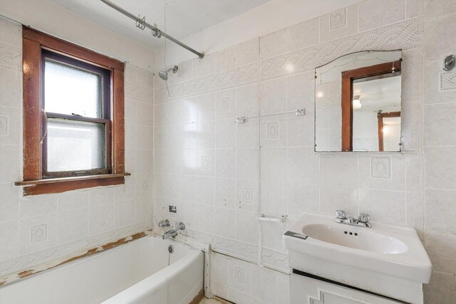 9241 S Blackstone Ave, Chicago, IL 60619 - bathroom featuring shower / bathing tub combination, vanity, tile walls, and decorative backsplash