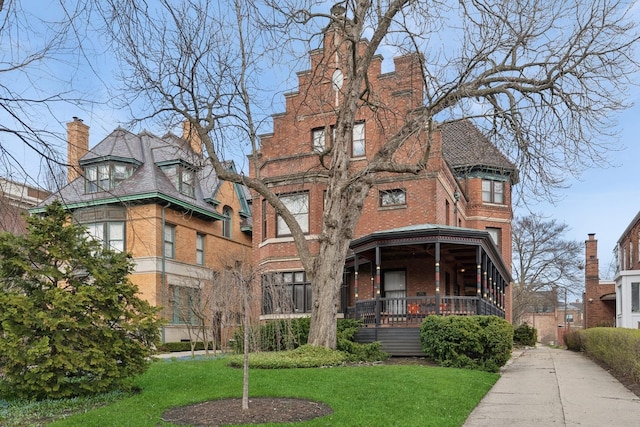 4923 S Greenwood Ave, Chicago, IL 60615 - view of front of property with brick siding, a front yard, a chimney, and covered porch
