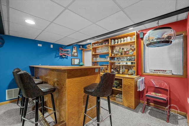 bar with a paneled ceiling, baseboards, carpet flooring, visible vents, and a dry bar