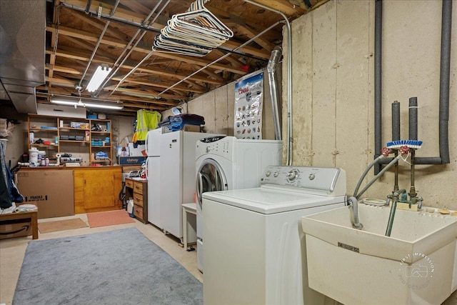 laundry room with laundry area, separate washer and dryer, and a sink