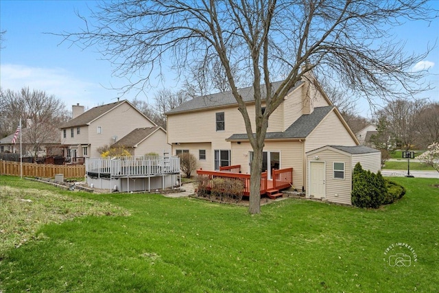 back of house featuring a wooden deck, a storage shed, a yard, an outdoor structure, and a fenced in pool