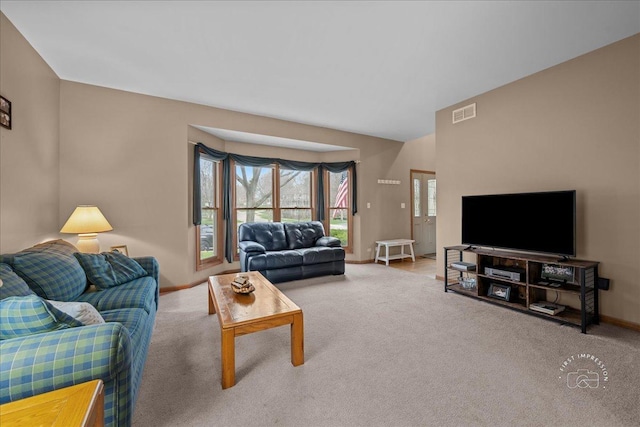 carpeted living area featuring visible vents and baseboards