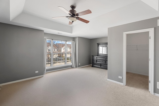 2366 Georgetown Cir, Aurora, IL 60503 - unfurnished bedroom featuring baseboards, a tray ceiling, a spacious closet, and carpet