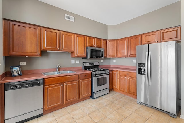 2366 Georgetown Cir, Aurora, IL 60503 - kitchen featuring a sink, appliances with stainless steel finishes, brown cabinets, light tile patterned floors, and visible vents