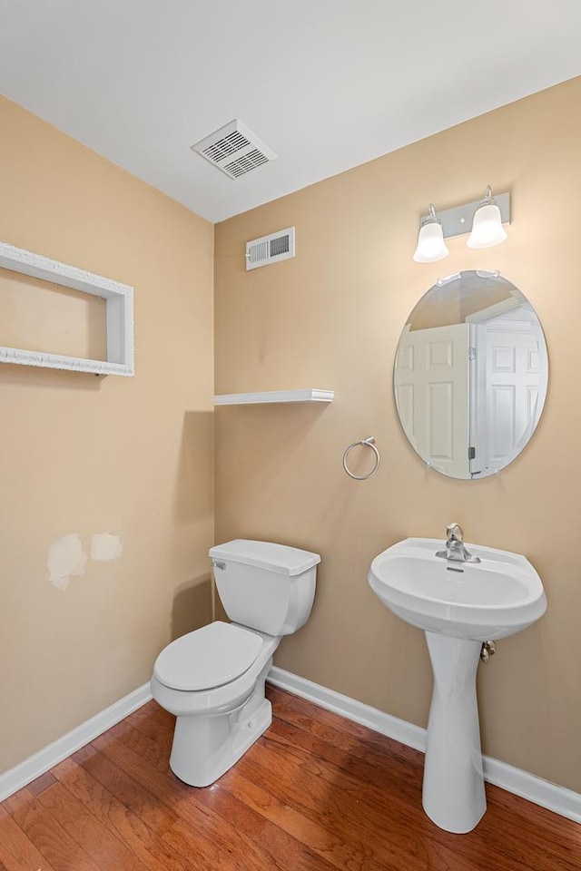 2366 Georgetown Cir, Aurora, IL 60503 - half bathroom with baseboards, visible vents, toilet, and wood finished floors