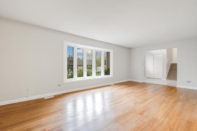 407 Brad Ct, Naperville, IL 60565 - unfurnished room with baseboards, light wood-style flooring, and stairs
