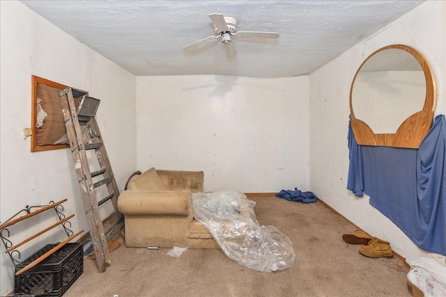 living area featuring a textured ceiling, a ceiling fan, and carpet