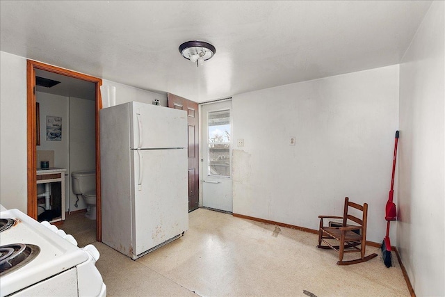 kitchen with baseboards and white appliances