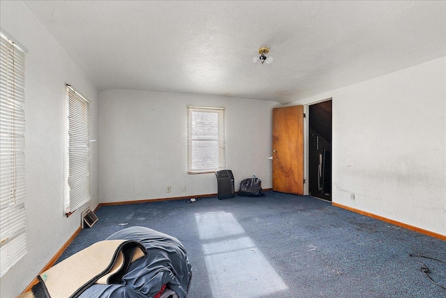 carpeted spare room with baseboards and a textured ceiling