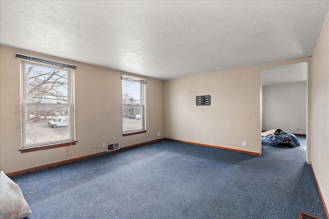 unfurnished room featuring baseboards, visible vents, carpet floors, and a textured ceiling
