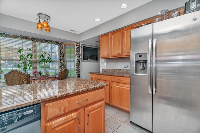 kitchen with light stone counters, dishwasher, visible vents, light tile patterned floors, and stainless steel fridge