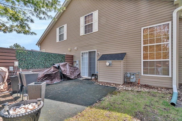 back of house featuring a fire pit, a patio, and fence