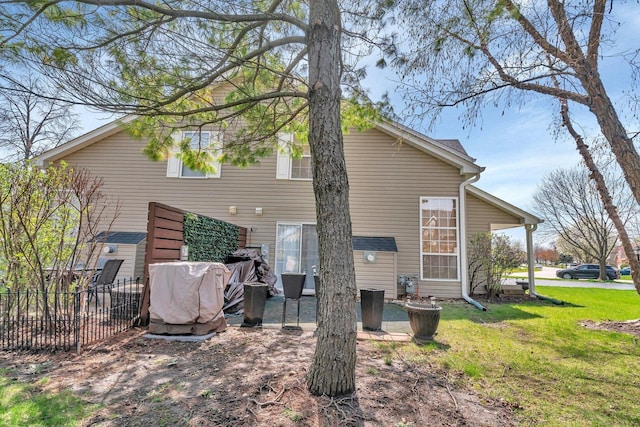 back of house featuring a lawn and a patio