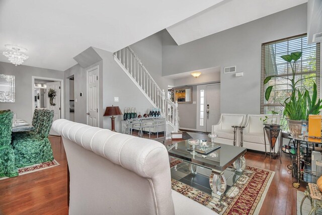 living area with stairway, visible vents, and hardwood / wood-style flooring