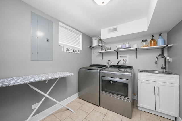 washroom with washing machine and clothes dryer, a sink, visible vents, cabinet space, and electric panel