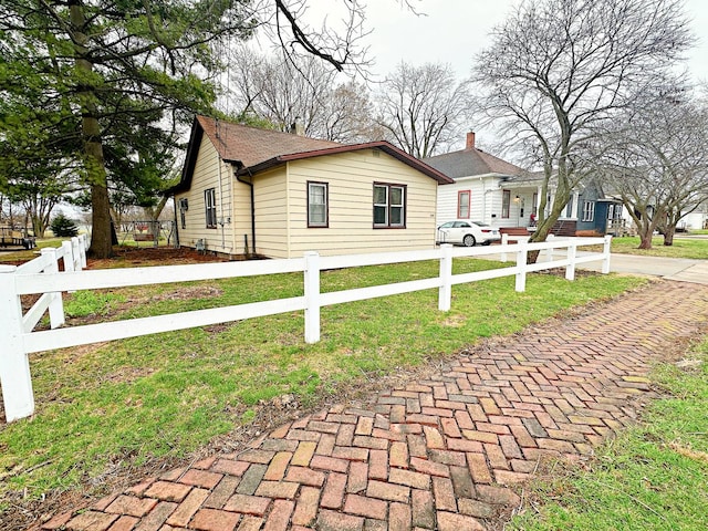 view of front of home with a front yard, a fenced front yard, and concrete driveway