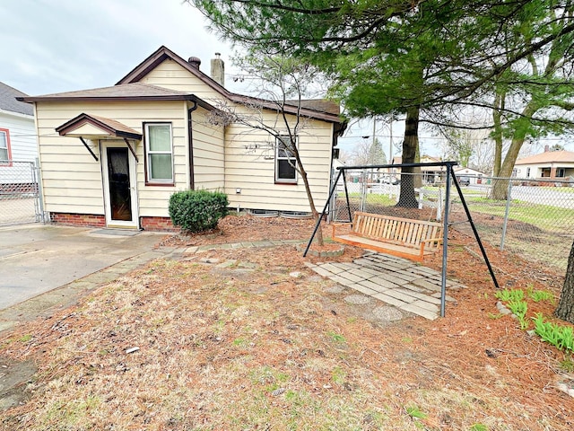 back of house with a chimney and fence
