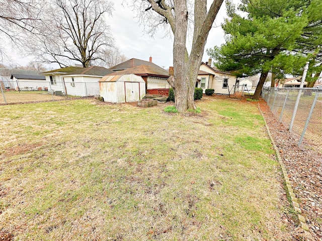 view of yard with a fenced backyard, a shed, and an outdoor structure