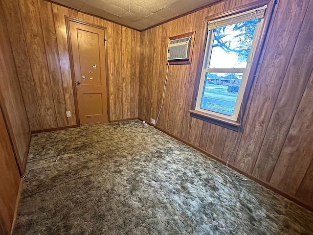 spare room featuring carpet, wood walls, a wall mounted air conditioner, and baseboards