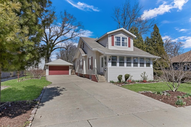 view of front of home with a detached garage, an outdoor structure, and a front yard