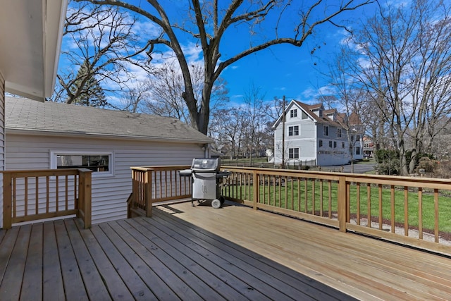 wooden deck featuring a grill, a residential view, and a lawn