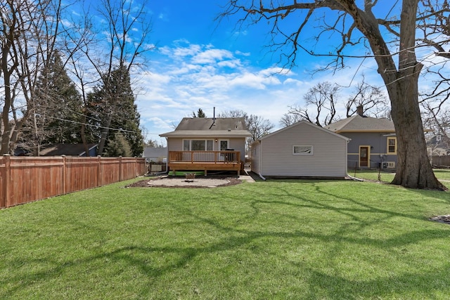 rear view of property featuring a yard, an outdoor structure, a fenced backyard, and a wooden deck