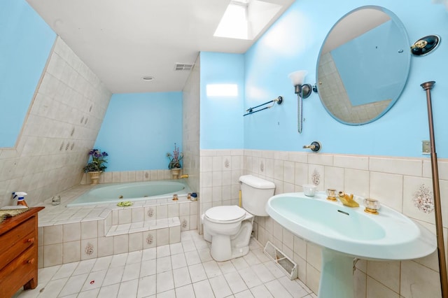3917 Sunset Ave, Markham, IL 60428 - bathroom with tile patterned floors, toilet, a relaxing tiled tub, visible vents, and tile walls