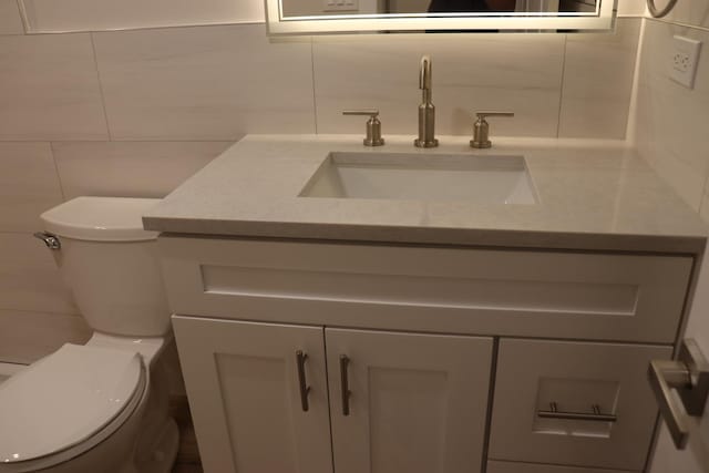3418 N Nordica Ave, Chicago, IL 60634 - half bathroom featuring tile walls, toilet, backsplash, and vanity
