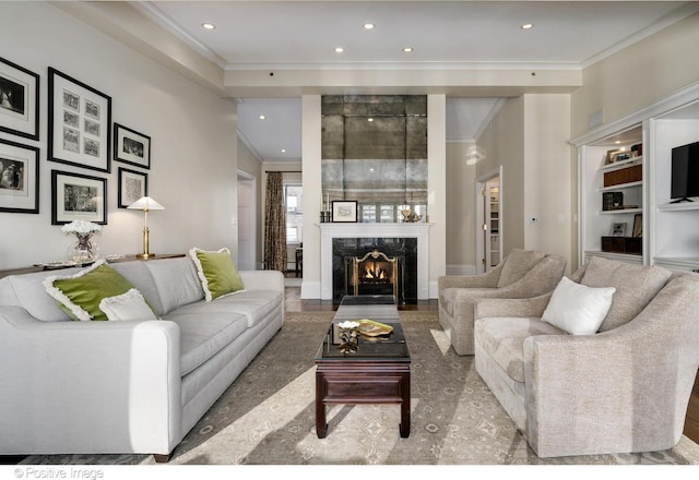 living room with crown molding, a fireplace, and recessed lighting
