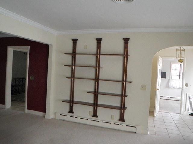 810 13th Ave, Mendota, IL 61342 - empty room with a baseboard heating unit, baseboard heating, arched walkways, and ornamental molding